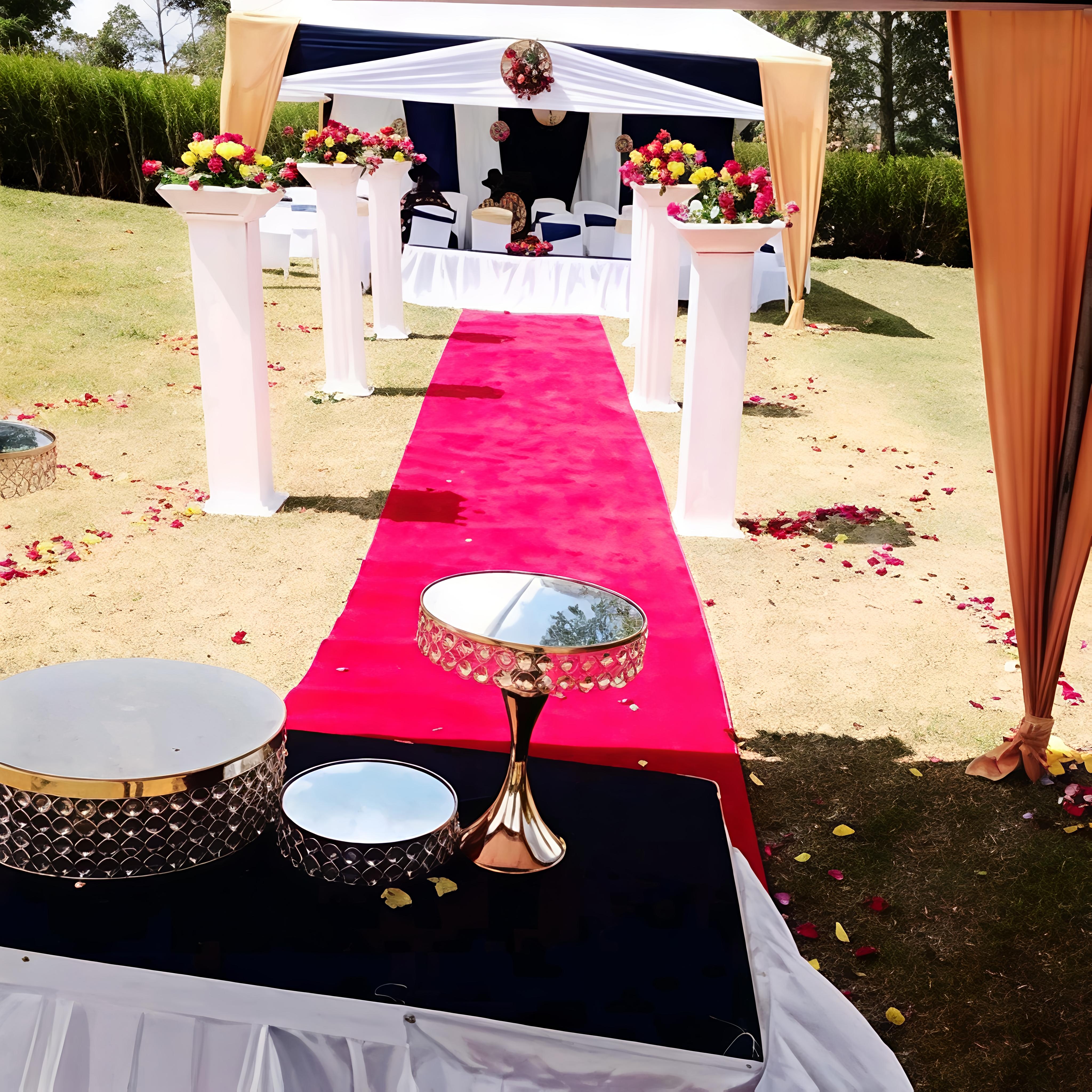 OB Prime Events outdoor setup with a red carpet, white tent, aisle pillars, and floral décor